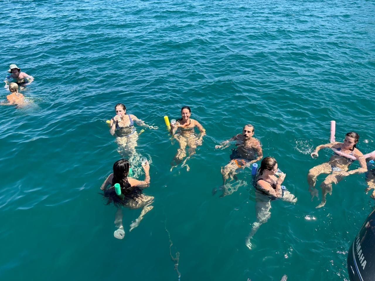 Guests floating in the ocean with drinks